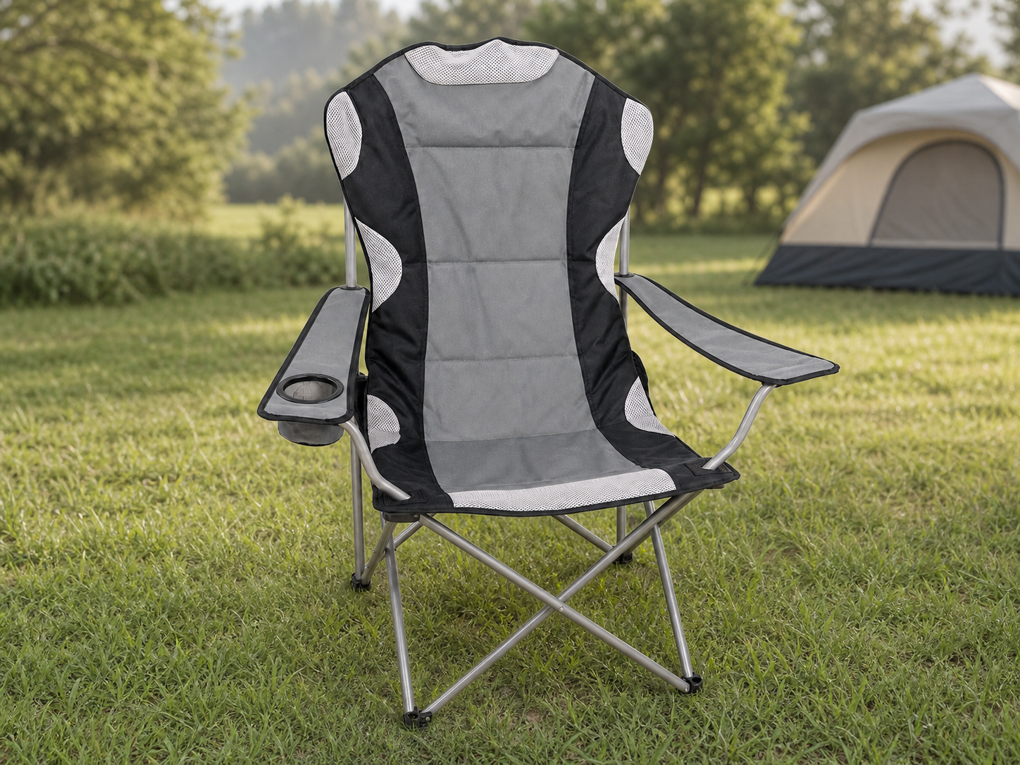 Grauer Campingstuhl mit Armlehnen und Getränkehalter auf einem Campingplatz